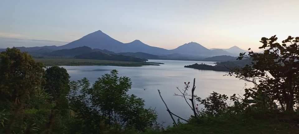 Lush morning view of Lake Mutanda and Virunga Volcanoes